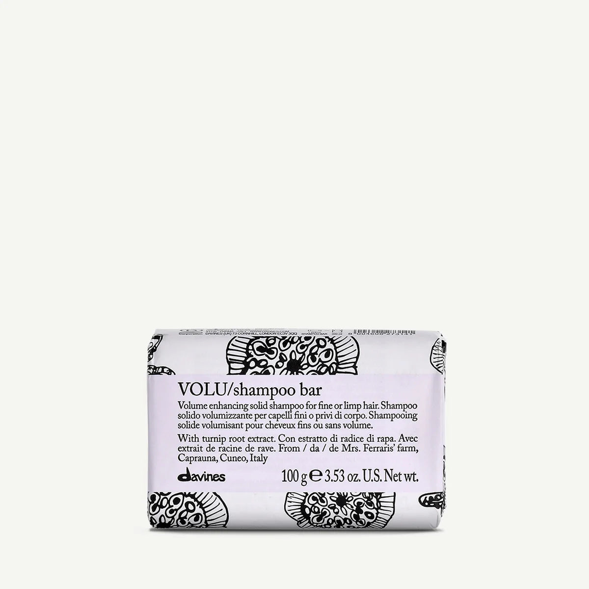 Davines VOLU Shampoo Bar, 100g, wrapped in white packaging with black floral patterns. Designed to add volume to fine or limp hair, this shampoo bar features turnip root extract from a farm in Caprauna, Italy.