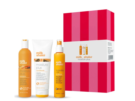 Milk Shake Moisture Plus Trio Christmas Gift Pack, featuring three products: a 300 ml shampoo, 250 ml conditioner, and 150 ml Incredible Milk spray, all displayed alongside a pink and red striped gift box.
